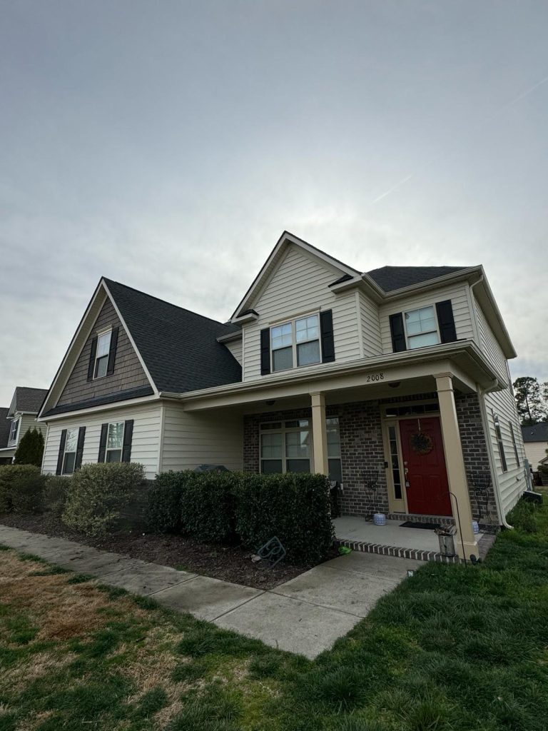 Single-story brick home with a two-car garage and newly installed shingle roof in Raleigh, NC
