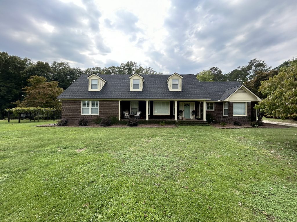Large single-story brick home with a freshly installed dark gray shingle roof in Myrtle Beach, SC