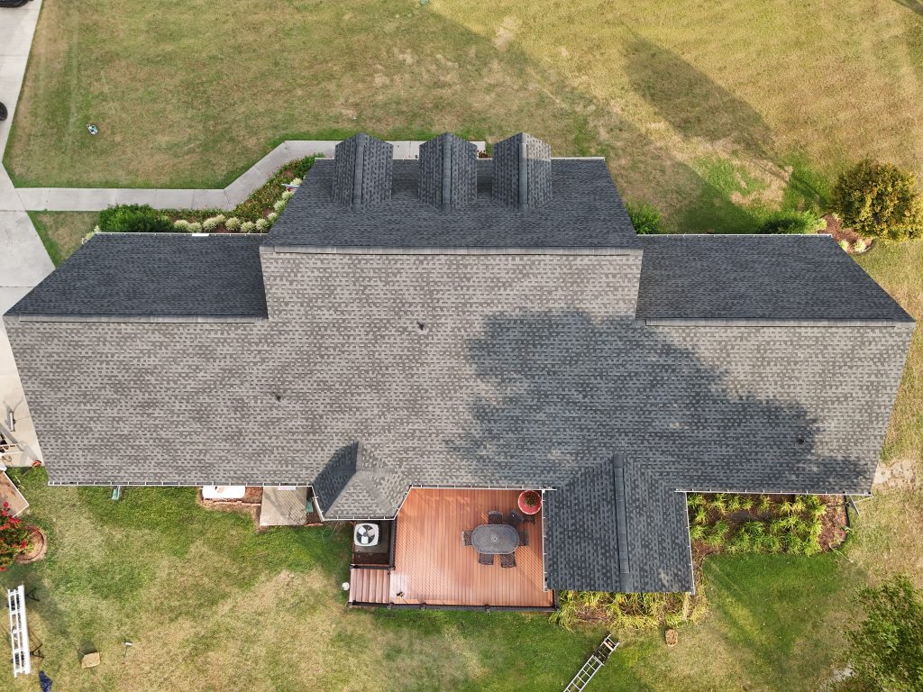 Brick home with dormer windows and a freshly installed shingle roof in Raleigh, NC