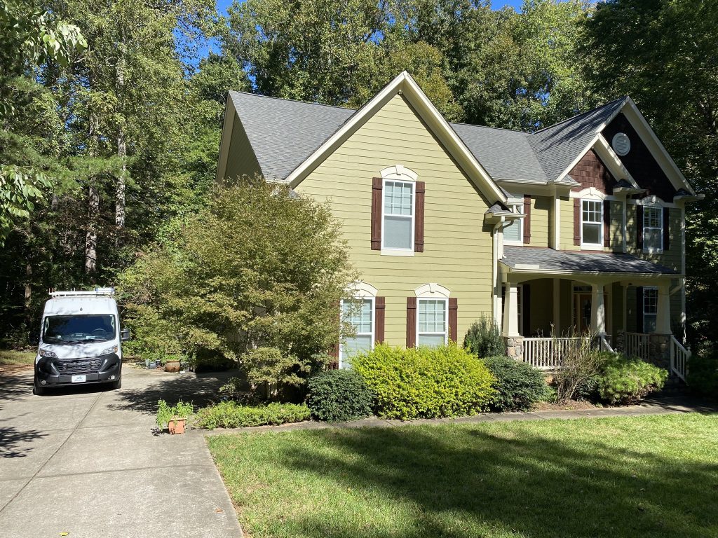 Brick ranch home with a covered front porch and new shingle roof in Raleigh, NC