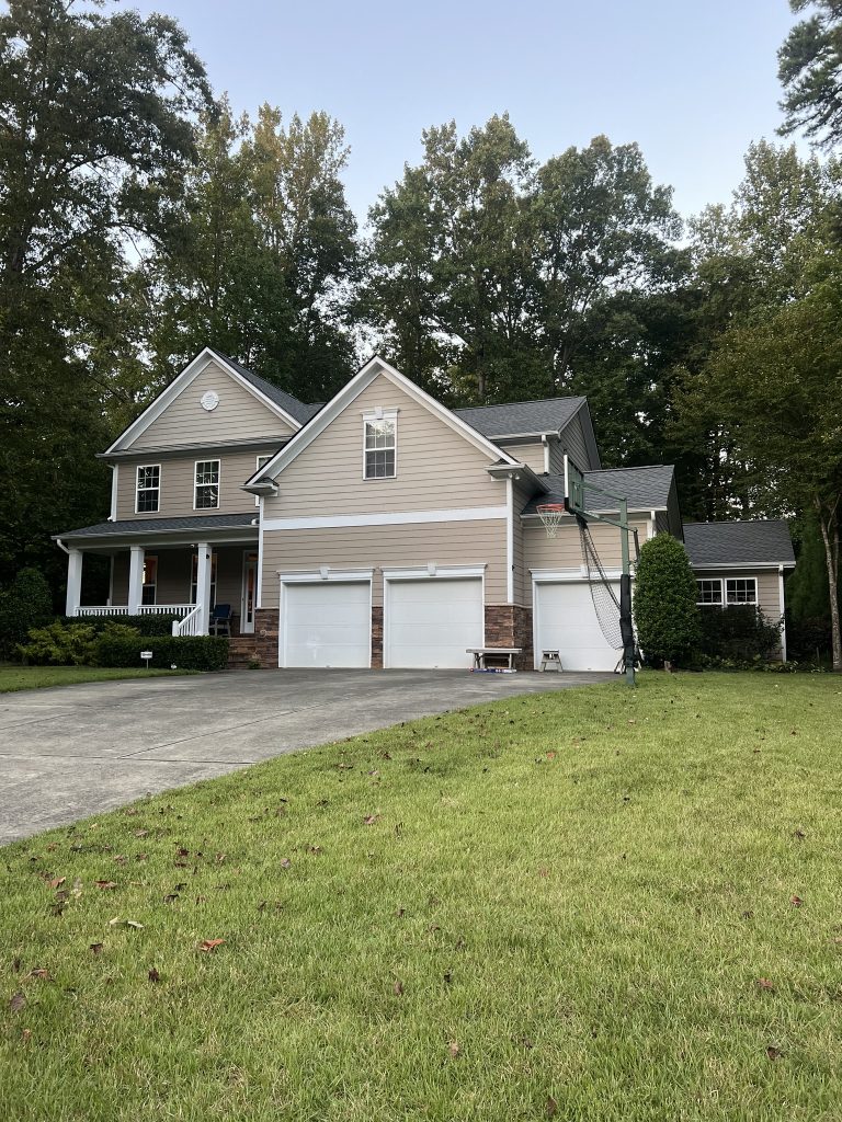 Single-story home with a new architectural shingle roof and mature trees in Raleigh, NC