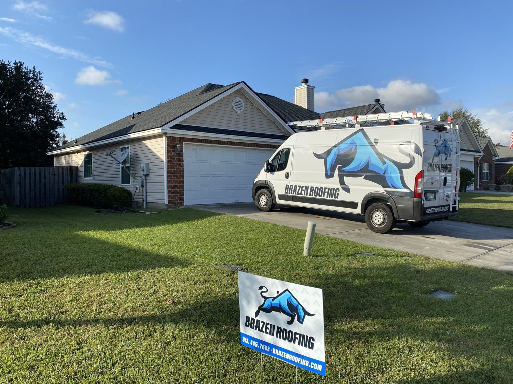 Tan single-story home with a Brazen Roofing service van and yard sign after a roof installation in Savannah, GA