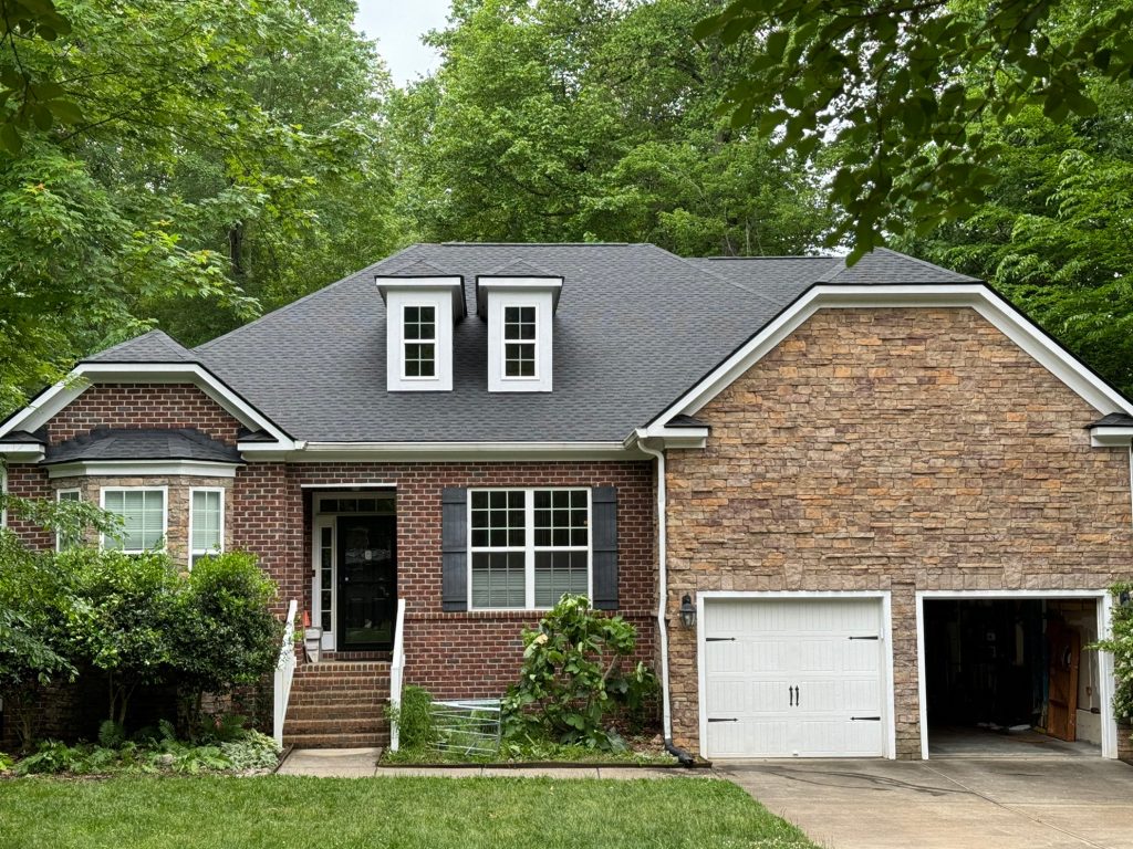 Single-story brick and stone-accent home with dormer windows and a new shingle roof in Raleigh, NC