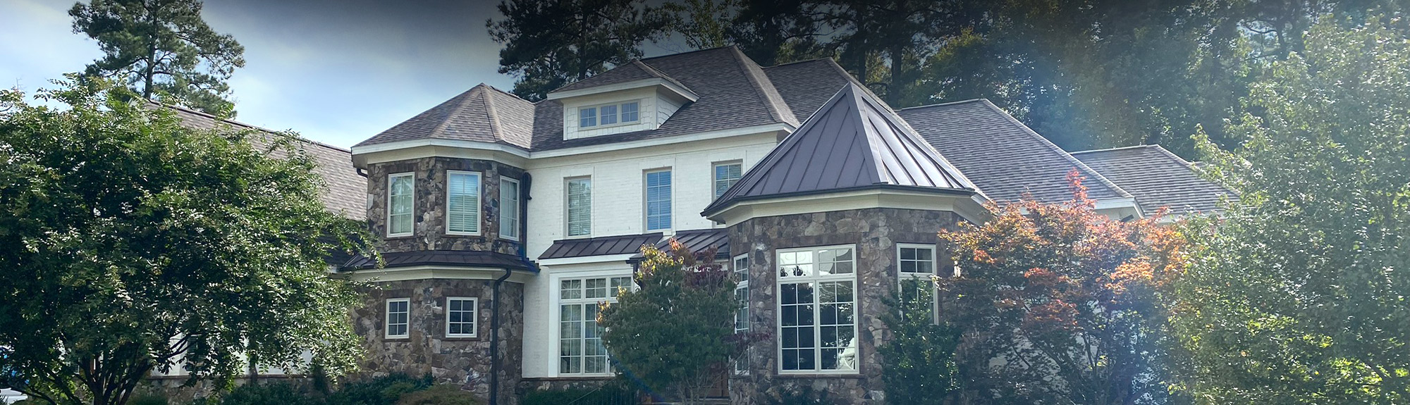 Luxury home with a new dimensional asphalt shingle roof and metal roof accents in Raleigh, NC